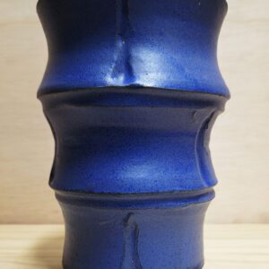 A blue vase sitting on top of a wooden table.