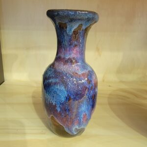 A blue vase sitting on top of a wooden table.