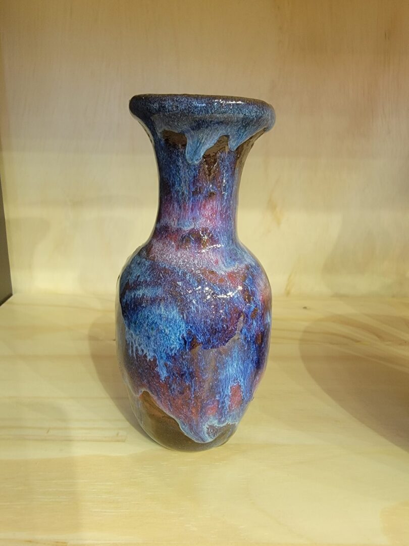 A blue vase sitting on top of a wooden table.