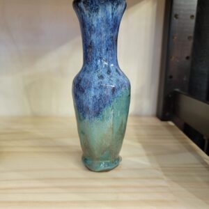 A blue vase sitting on top of a wooden table.