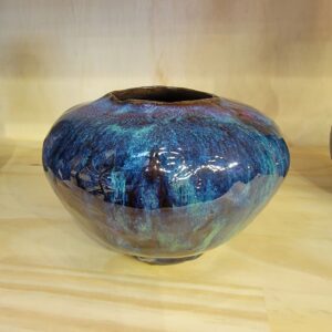 A blue vase sitting on top of a wooden table.