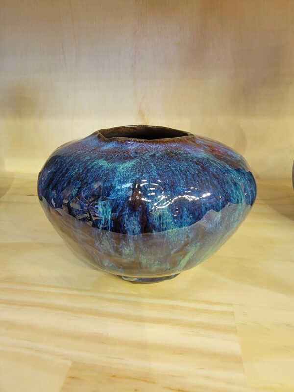 A blue vase sitting on top of a wooden table.