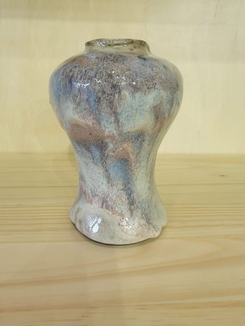 A small vase sitting on top of a wooden table.