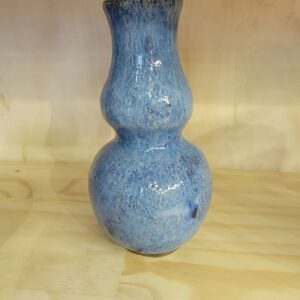 A blue vase sitting on top of a wooden table.