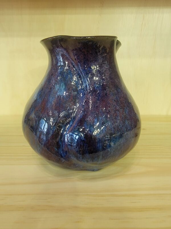 A blue vase sitting on top of a wooden table.