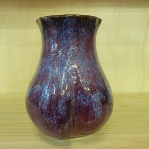 A vase sitting on top of a wooden table.