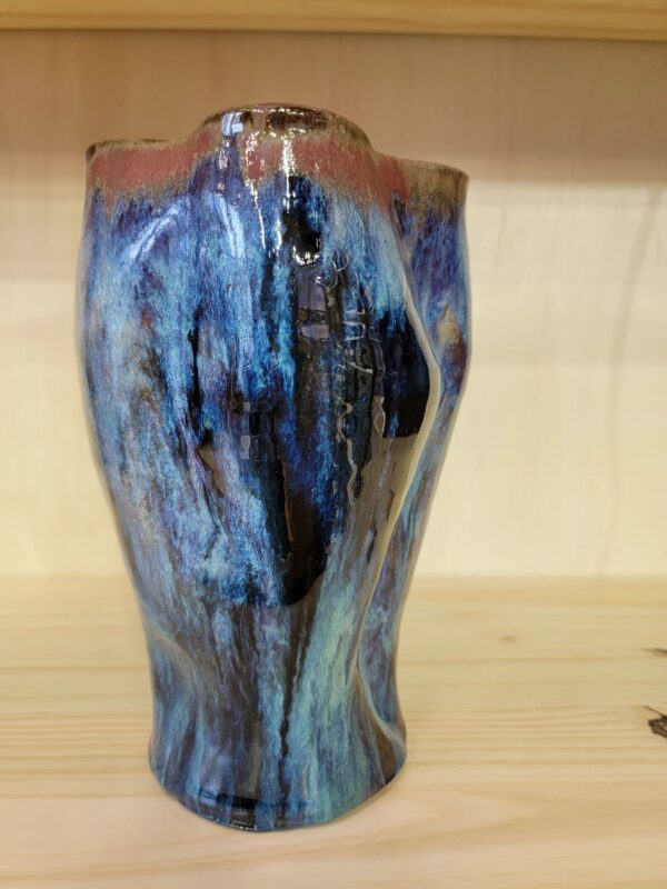 A blue vase sitting on top of a wooden table.