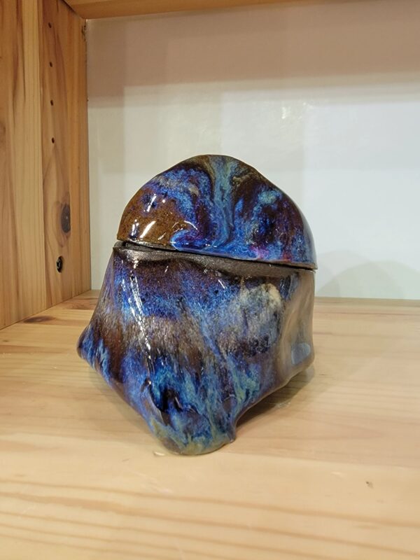 A blue and brown ceramic bowl sitting on top of a wooden table.