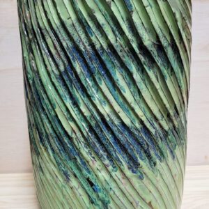 A green vase with some blue and black lines