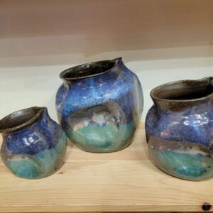 Three vases are shown on a shelf.