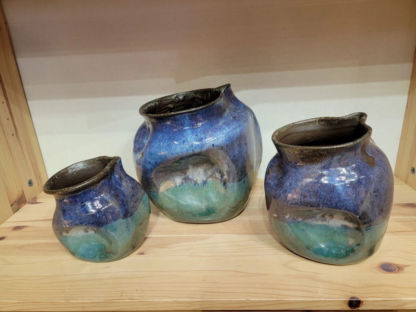 Three vases are shown on a shelf.