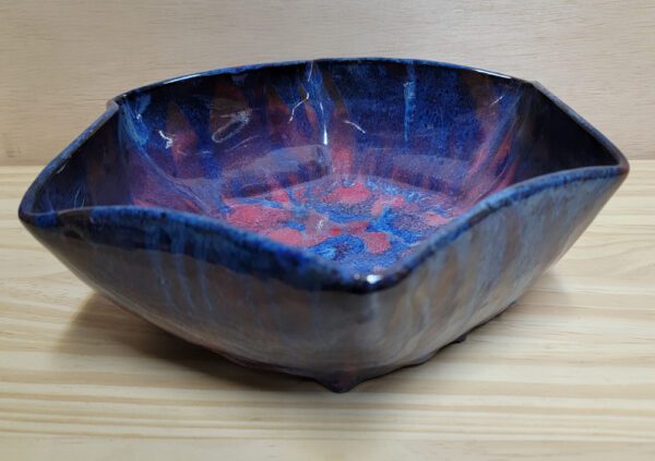 A blue bowl with red and purple swirls on it