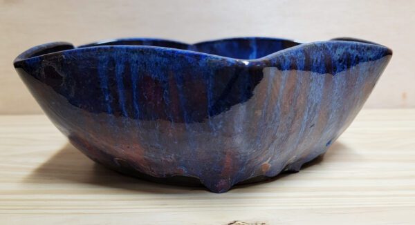 A blue bowl sitting on top of a wooden table.