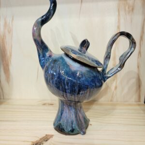 A blue teapot with two handles and a lid.