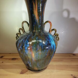 A large vase sitting on top of a wooden table.