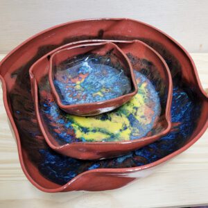 A set of three bowls with different designs on them.