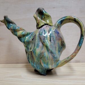 A ceramic teapot with a twisted handle and a lid.