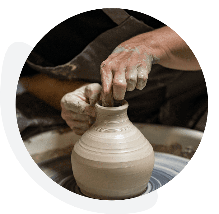 A person is making pottery on the potter 's wheel.